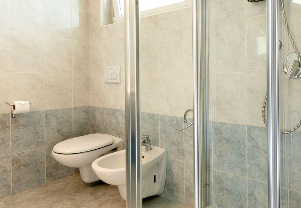 Modern bathroom with shower, bidet, and open window.