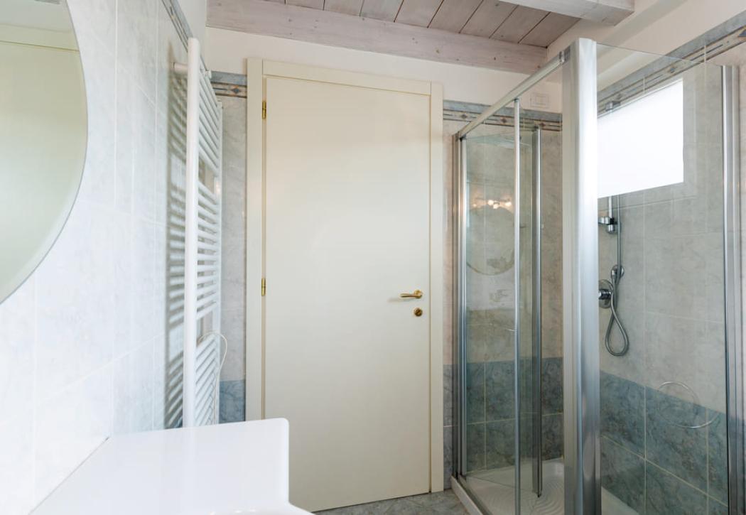 Modern bathroom with glass shower and white door.