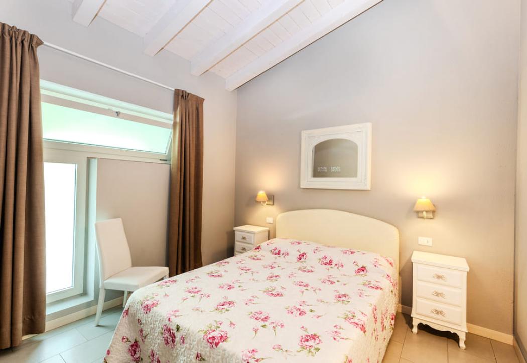 Camera da letto accogliente con letto matrimoniale e arredamento in stile classico.