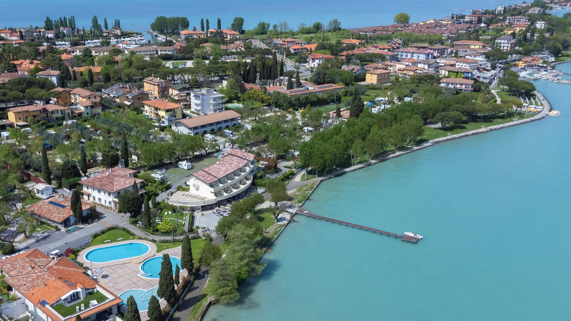 Vue aérienne d'une ville côtière avec piscine et lac.