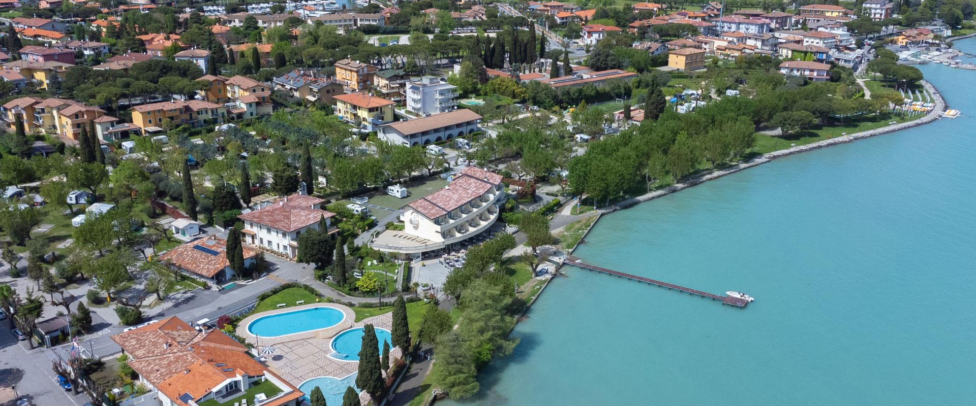Aerial view of a tourist complex with pool and lake access.