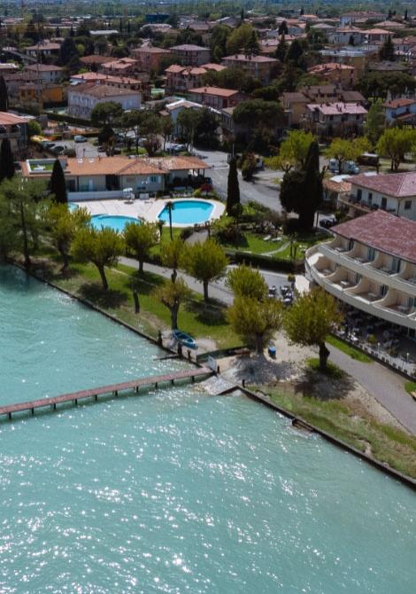 Vista aerea di un hotel con piscina vicino a un lago.