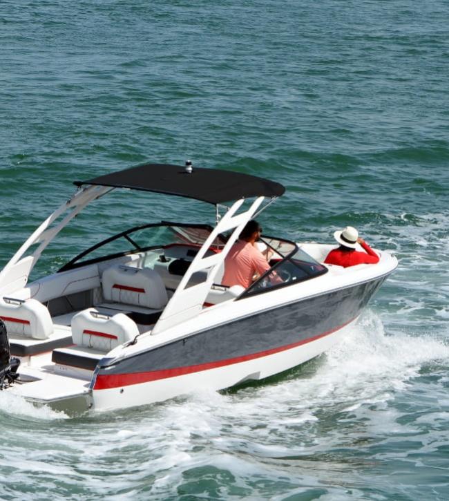Motorboot mit zwei Personen, die auf ruhigem Wasser fahren.