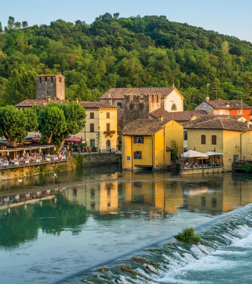 Un pittoresco villaggio con case colorate e un fiume tranquillo.